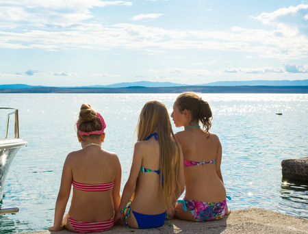 Three girls having rest on a beach near the seaの写真素材