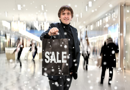 Smiling man n with shopping bag at shopping mallの写真素材