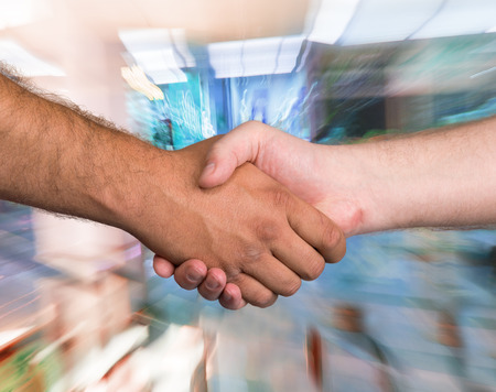 Two men shaking hands on a blurred backgroundの写真素材