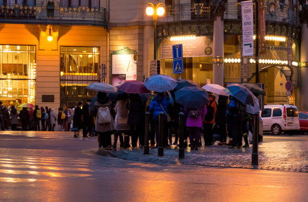 PRAGUE, CZECH REPUBLIC - 03 January 2015: Crowd of people under umbrellas on zebra crossing in Prague, Czech republicのeditorial素材