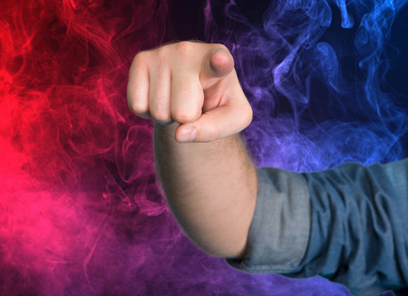 Man pointing out towards you against smoky backgroundの写真素材