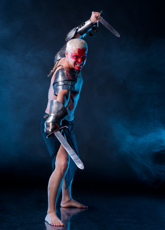Knight with a sword on a blue smoky backgroundの写真素材