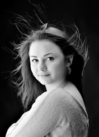 Beautiful Brunette Girl with streaming hair on a dark backgroundの写真素材