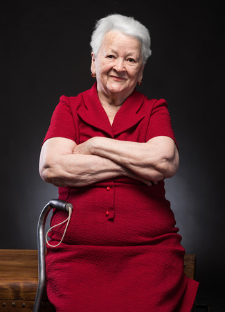 Portrait of beautiful smiling old woman on a dark backgroundの写真素材