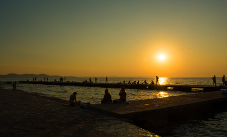 People enjoying summer time on the beach.Beautiful sunsetのeditorial素材