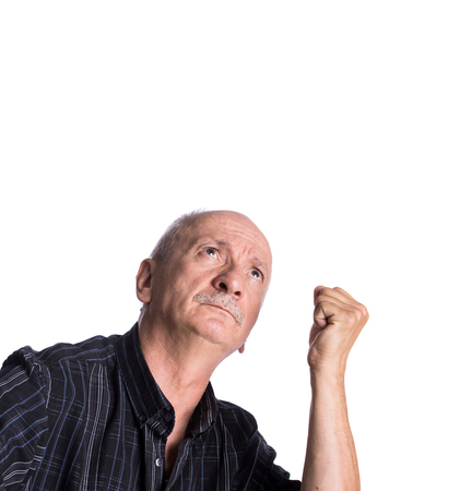 Elderly man threatening with a fist on a white background with a copy-spaceの写真素材