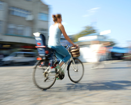Woman cyclist in traffic on the city roadway. Intentional motion blurの写真素材