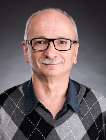 Portrait of a senior smiling man on a dark backgroundの写真素材