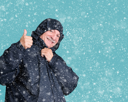 Portrait of senior smiling man on a blue background. Winter concept