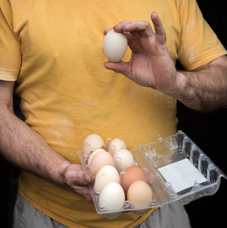 Farmer holding fresh organic eggs. Poultry yardの写真素材