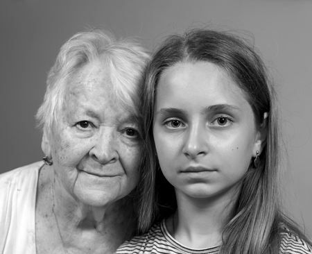 Portrait of sad grandmother and granddaughter at homeの写真素材