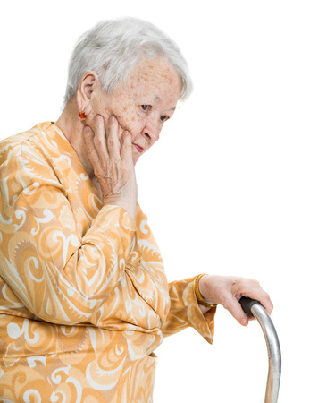 Old sad woman standing with a cane posing on a white background

の写真素材