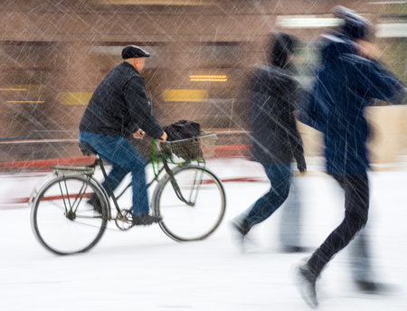 Cyclist on the city roadway in motion blur. Winter snowy dayの写真素材
