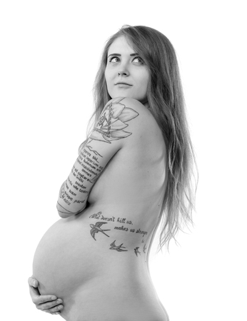 Pregnant nude woman with long blonde hair posing in studio on a white backgroundの写真素材