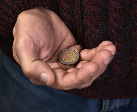 Close-up of old mans hands holding pile of coinsの写真素材