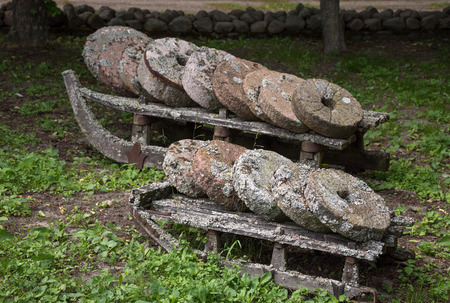 Old moss-covered stone millstones outdoorsの写真素材