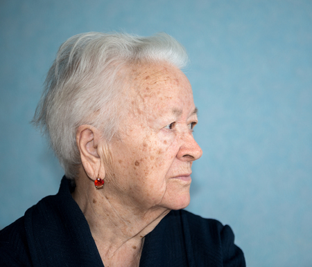 Portrait of old gray-haired sad woman at home. Sick depressed old womanの写真素材