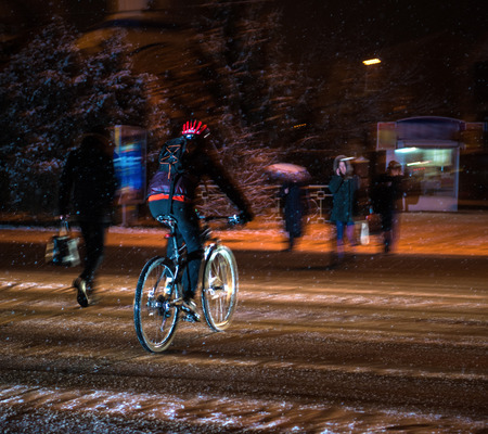 Cyclist on the city roadway in motion blur at night