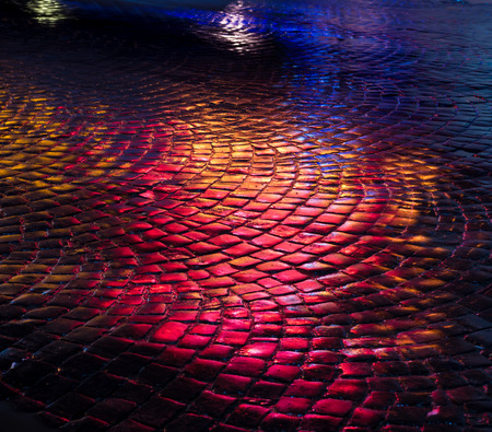 Abstract urban background. Streets after rain with reflections of light on wet roadway. Pavement textureの写真素材