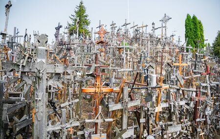 SIAULIAI, LITHUANIA - JULY 28, 2019:A large number of wooden crosses and crucifixes at the Hill of Crosses. Ð¢ext on the crosses in different languages - O God, protect our family, give healthのeditorial素材