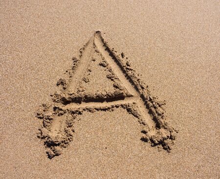 Sand Beach Alphabet: Letter A. Alphabet's letter A handwritten in sand on the beachの写真素材