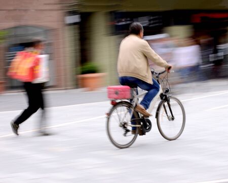Cyclist on the city roadway in motion blur. Intentional motion blur. Defocused imageの写真素材
