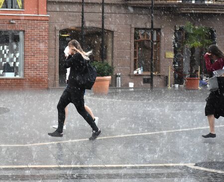 People running down the street on rainy day. Intentional motion blur. Defocused image