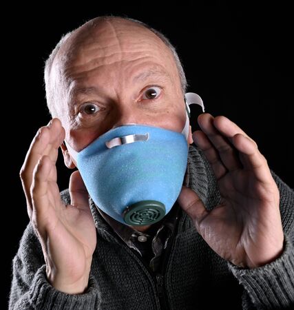 Healthcare and medicine concept. Sick old man posing in mask s over black backgroundの写真素材