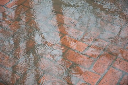 Rain in the city. Rain drops on the puddle