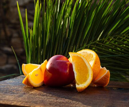 Fresh organic oranges on a wooden table in the sun