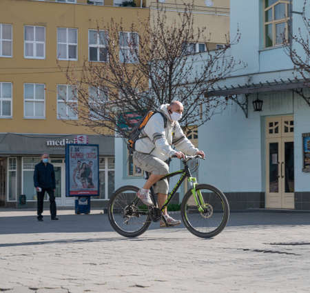 UZHHOROD, UKRAINE - APRIL 10, 2020: Quarantine in the city of Uzhhorod due to the COVID-19 virus. People in protective masks in the streets of the cityのeditorial素材