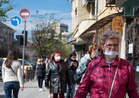 UZHHOROD, UKRAINE - APRIL 10, 2020: Quarantine in the city of Uzhhorod due to the COVID-19 virus. People in protective masks in the streets of the cityのeditorial素材