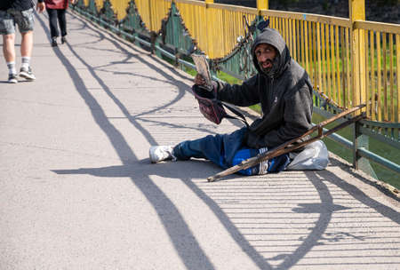 UZHHOROD, UKRAINE - APRIL 10, 2020: Homeless man begging for alms on a city street of Uzhhorod,...