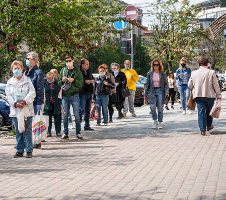 UZHHOROD, UKRAINE - APRIL 29, 2020: Queue to the market during an epidemic in the city of Uzhhorod. Waiting at a safe distance apart from each other during the Coronavirus pandemicのeditorial素材