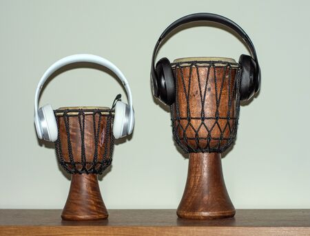 Two pairs of headphones on drums