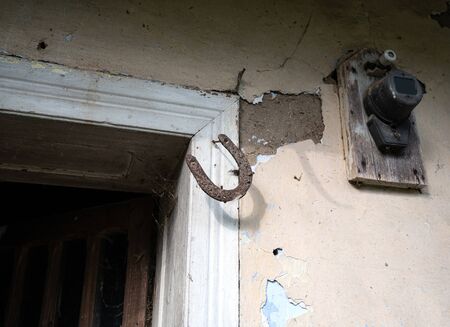 Old rusty horseshoe hanging on a door jamb. Lucky symbol