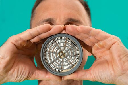 Worker holding respirator filter before faceの写真素材