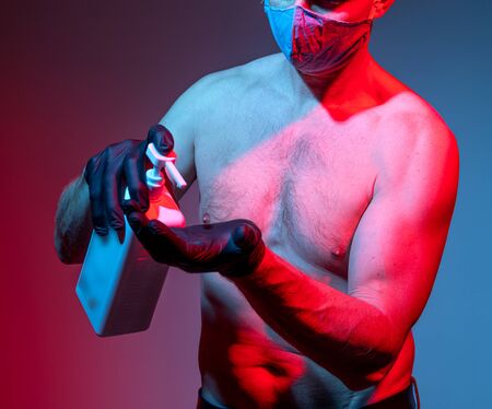 Healthcare and medical concept. Man in mask holding a bottle of hand sanitizerの写真素材