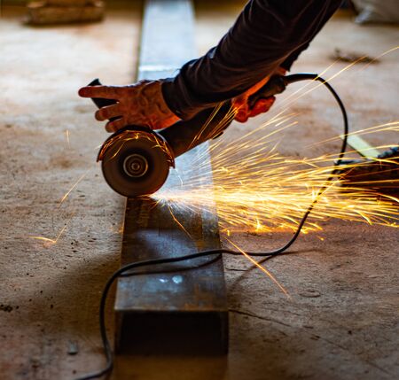 Metal work with the flex. Man cutting channel on the construction site
