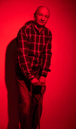 Senior man posing with a cane in studioの写真素材