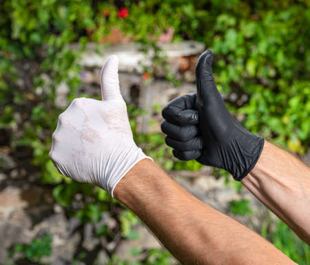 People in protective gloves showing YES sign outdoors