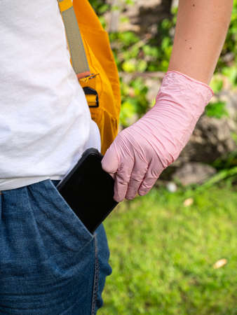 Healthcare concept. Girl in protective gloves gets out the phone from the pocketの写真素材