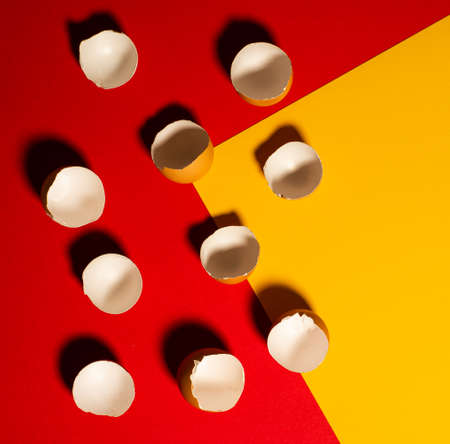 Broken brown eggshells on a red yellow background