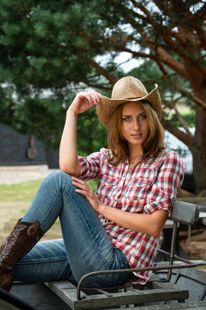 Portrait of young attractive cowgirl in hat posing outdoorsの写真素材