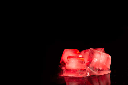 Several red  ice cubes on a black mirror backgroundの写真素材