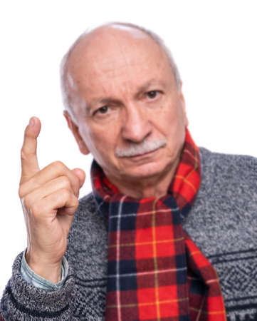 Serious man raising forefinger in warning gesture over white backgroundの写真素材