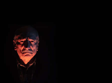 Portrait of scary looking man over dark background