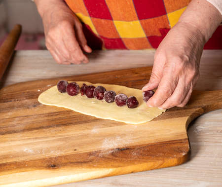 Dessert concept. Woman preparing cherry sticks for pie Monastic hut  at homeの写真素材