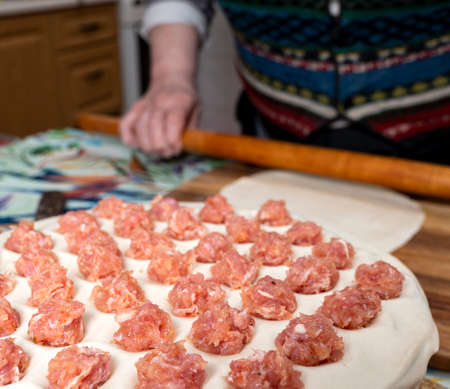 Woman cooking delicious homemade dumplings on the kitchen at homeの写真素材
