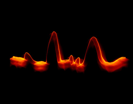 Light wave trail path, vibrant neon gold color in abstract swirls on a black background. Light paintingの写真素材